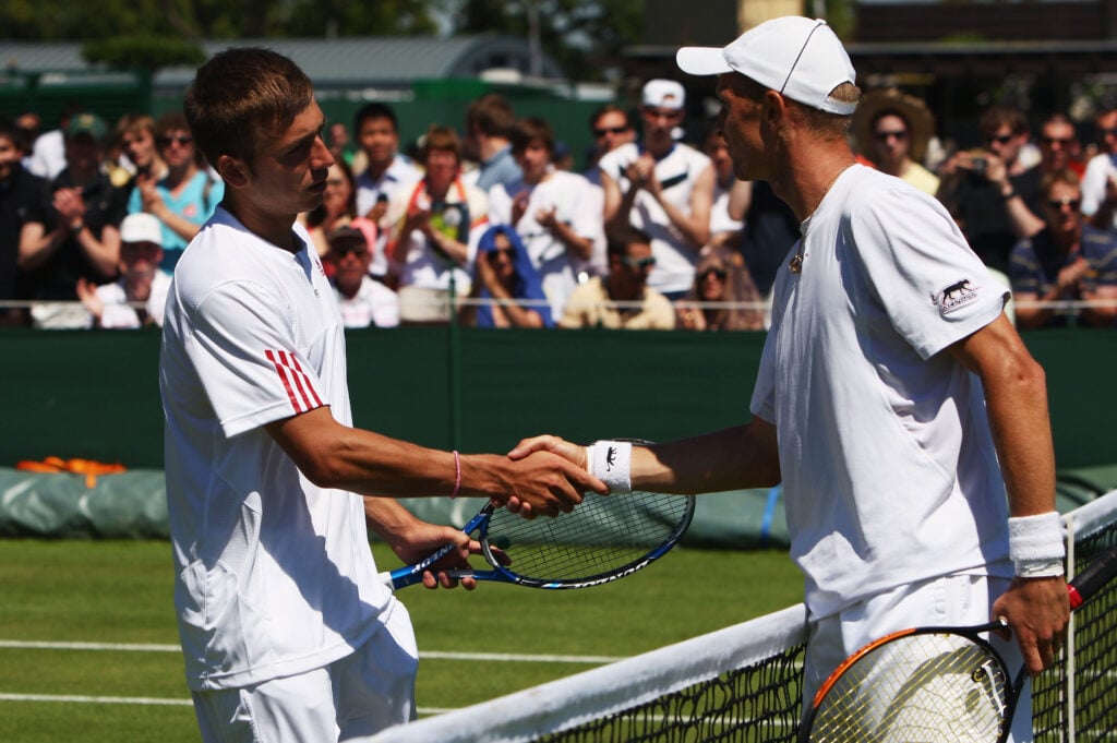 Daniel Evans of Great Britain (L) shakes hands after defeat by Nikolay Davydenko of Russia during the men's singles first round match on Day Two of the Wimbledon Lawn Tennis Championships at the All England Lawn Tennis and Croquet Club on June 23, 2009 in London, England.