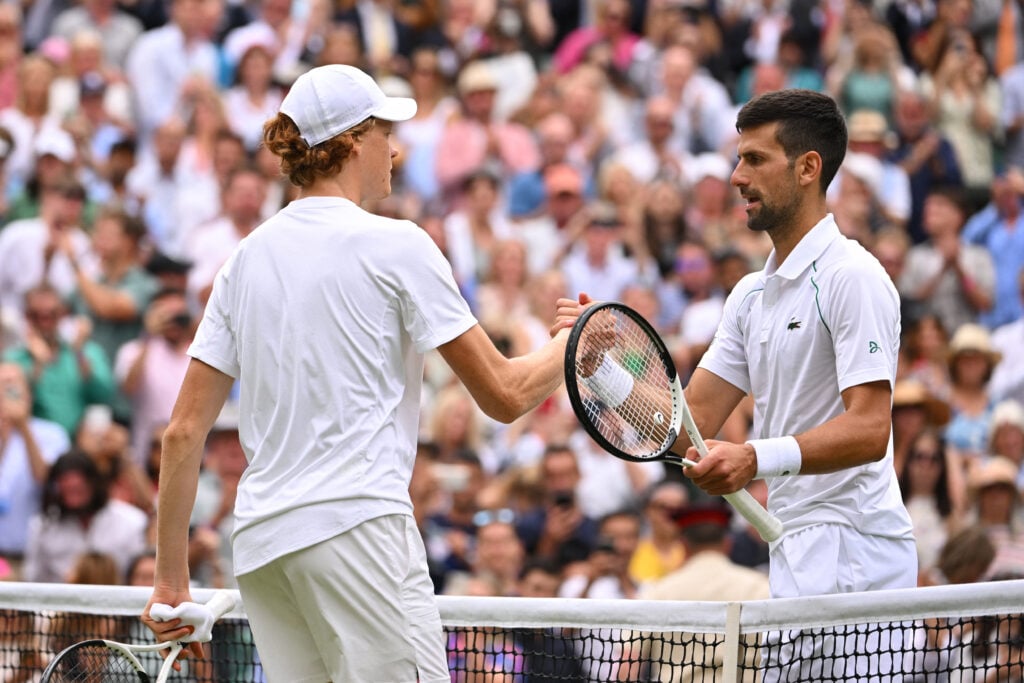 Serbia's Novak Djokovic and Italy's Jannik Sinner shake hands after their men's singles quarter final tennis match on the ninth day of the 2022 Wimbledon Championships at The All England Tennis Club in Wimbledon, southwest London, on July 5, 2022.