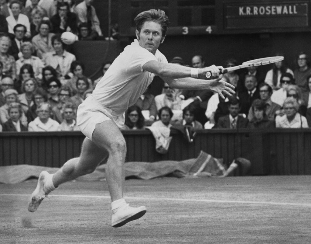 Cliff Richey of the United States keeps his eyes on the tennis ball as he reaches to play a backhand return against Ken Rosewall of Australia during their Men's Singles Quarter Final match on Centre Court at the Wimbledon Lawn Tennis Championship on 29th June 1971 at the All England Lawn Tennis and Croquet Club in Wimbledon in London, England. Ken Rosewall won the match 6 - 8, 5 - 7, 6 - 4, 9 - 7, 7 - 5.