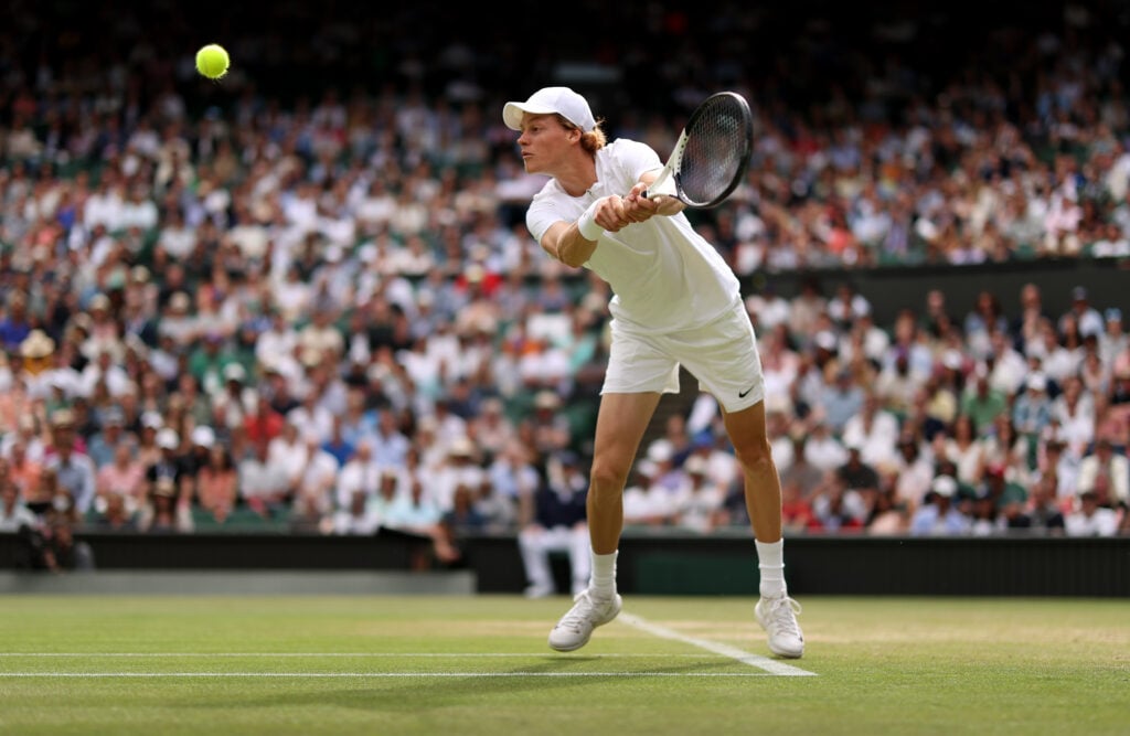 Jannik Sinner of Italy plays a backhand against Carlos Alcaraz of Spain during their Men's Singles Fourth Round match on day seven of The Championships Wimbledon 2022 at All England Lawn Tennis and Croquet Club on July 03, 2022 in London, England.