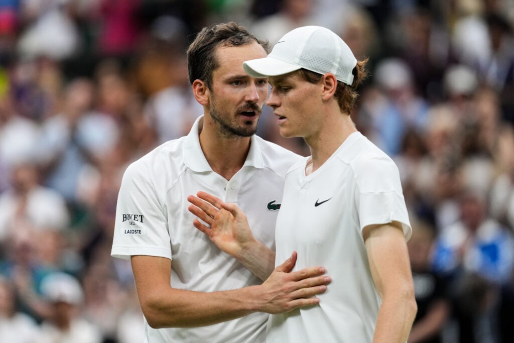 Jannik Sinner and Daniil Medvedev embrace after their 2024 Wimbledon quarter-final.