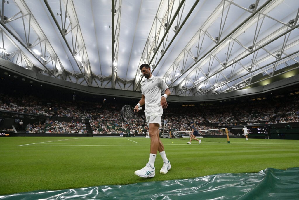 Serbia's Novak Djokovic walks on the court as he plays against France's Alexandre Muller under the closed roof of Centre Court during their men's singles first round tennis match on the second day of the 2025 Wimbledon Championships at The All England Lawn Tennis and Croquet Club in Wimbledon, southwest London, on July 1, 2025.