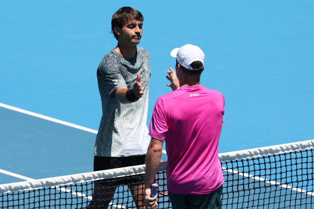 Winner Arthur Fery of Britain (R) shakes hands with Italy's Flavio Cobolli after the end of their men's singles match on day one of the Australian Open tennis tournament in Melbourne on January 18, 2026.