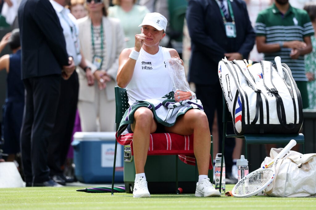 Iga Swiatek of Poland appears emotional as she sits in her seat after victory against Taylor Townsend of United States during their Ladies' Singles first round match on day two of The Championships Wimbledon 2026 at All England Lawn Tennis and Croquet Club on June 30, 2026 in London, England.