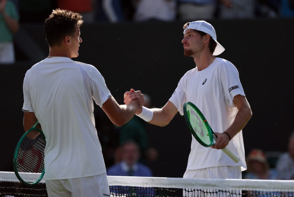 Toby Samuel of Great Britain and Jakub Mensik of Czechia interact at the net following their Gentlemen's Singles first round match on day two of The Championships Wimbledon 2026 at All England Lawn Tennis and Croquet Club on June 30, 2026 in London, England.