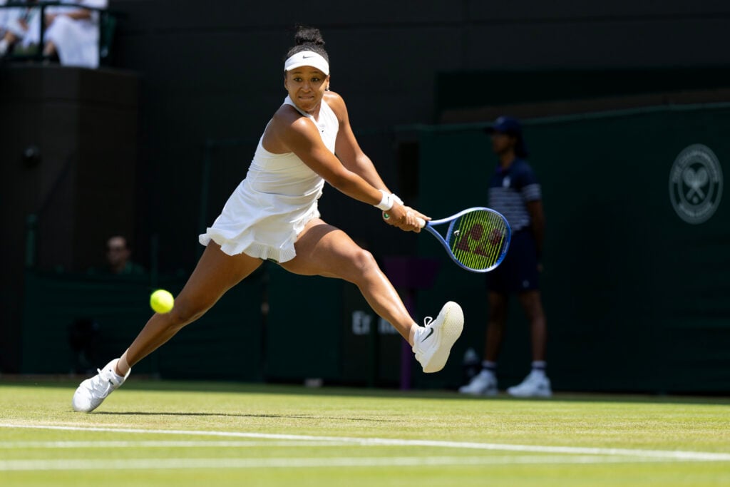Naomi Osaka hits a backhand at Wimbledon in 2026.