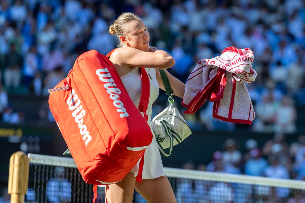 Amanda Anisimova walks off court after losing to Madison Keys at Wimbledon.