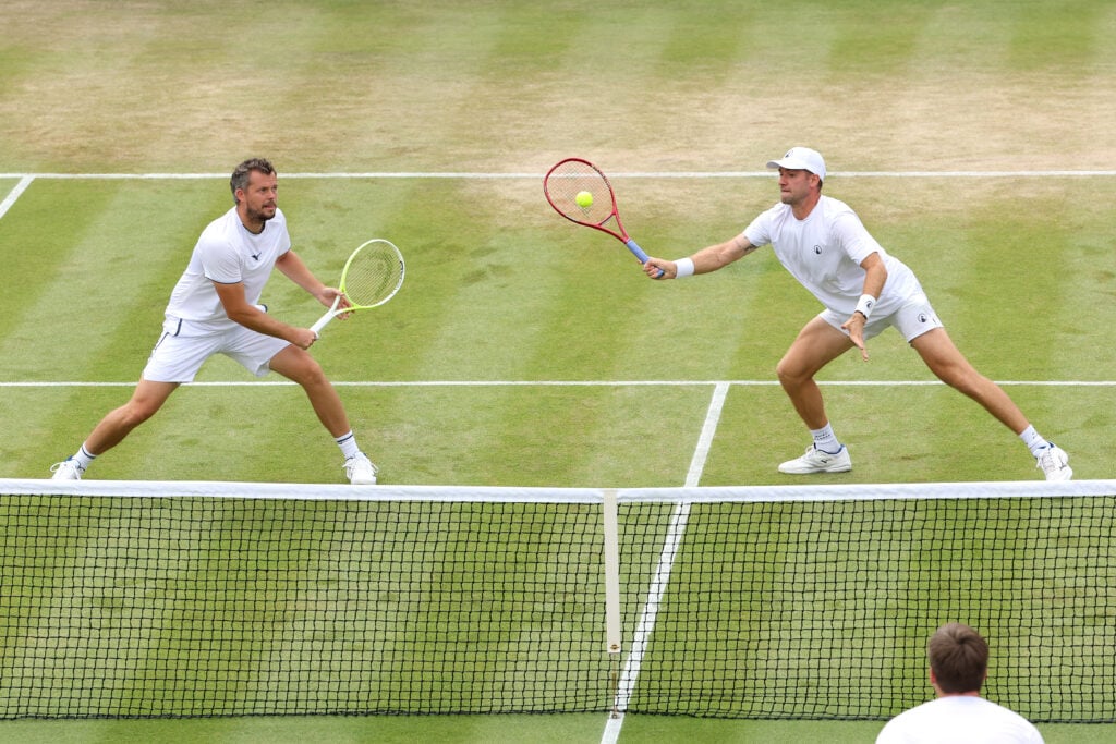 Patrik Rikl of Czechia plays a forehand with partner Adam Pavlasek of Czechia against Henry Patten of Great Britain and Harri Heliovaara of Finland during their Gentlemen's Doubles third round match on day seven of The Championships Wimbledon 2026 at All England Lawn Tennis and Croquet Club on July 05, 2026 in London, England.