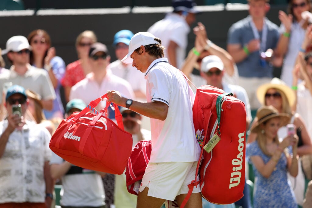 Alex de Minaur walks off court after losing to Flavio Cobolli at Wimbledon in 2026.