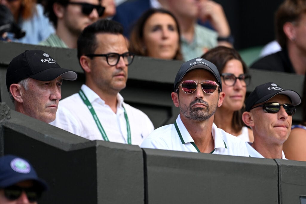 Darren Cahill and Simone Vagnozzi watch Jannik Sinner play Novak Djokovic at Wimbledon in 2026.