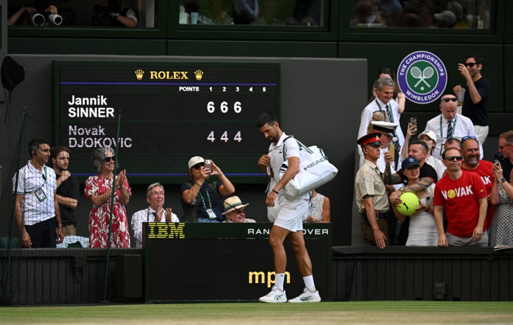 Novak Djokovic exits the court after losing the Wimbledon semi-final.