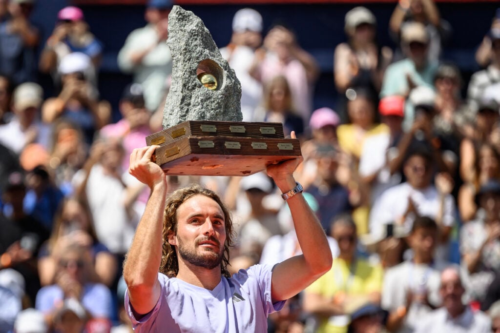 Greece's Stefanos Tsitsipas raises the trophy following his victory against Belgium's Raphael Collignon during their men's singles final match at the Swiss Open tennis tournament in Gstaad, on July 19, 2026.