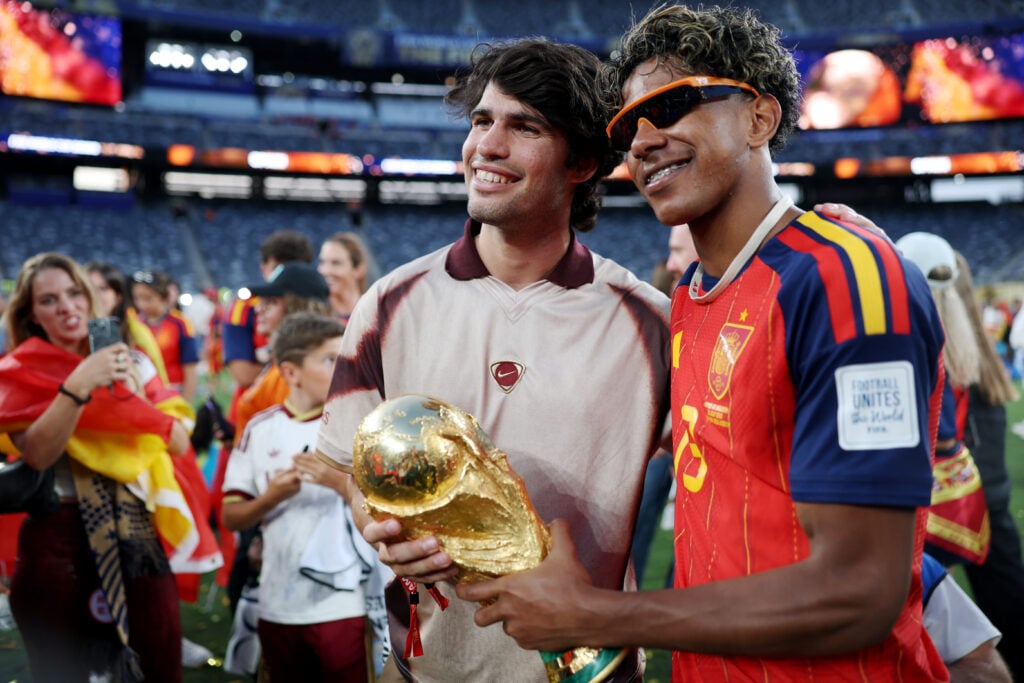 Carlos Alcaraz and Lamine Yamal pose with the World Cup trophy.