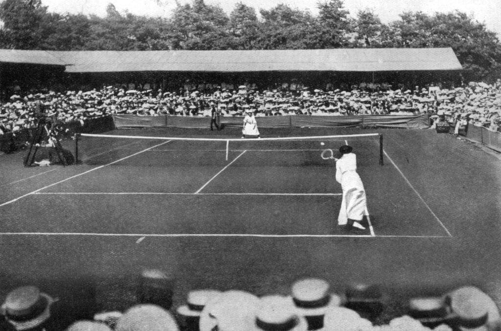 A women's final at the old Wimbledon, 1905. Miss Sutton challenging Miss D K Douglass. May Sutton became the first American woman to win the Wimbledon singles title. She beat British reigning champion Dorothea Douglass.