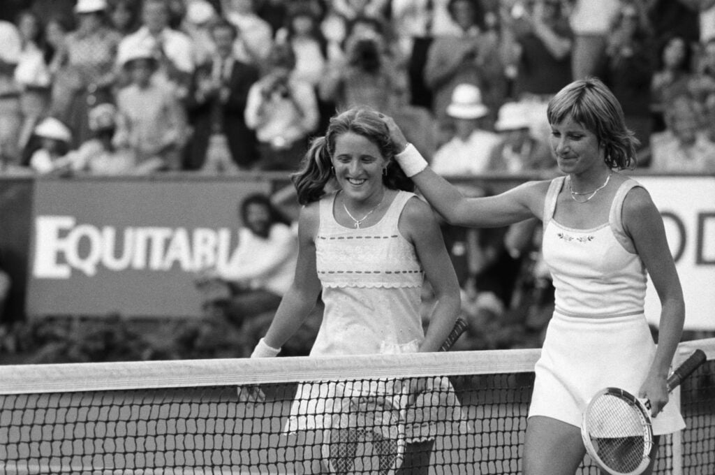 A gracious Chris Evert Lloyd (r) pats Tracy Austin on the head after Austin dethroned the four-time champion, 6-4, 6-3 in 90 minutes to win the U. S. Open Women's Singles Championship here Sept. 9. The 16-year-old Austin displayed the business side of her personality to become the youngest woman ever to win the national championship.