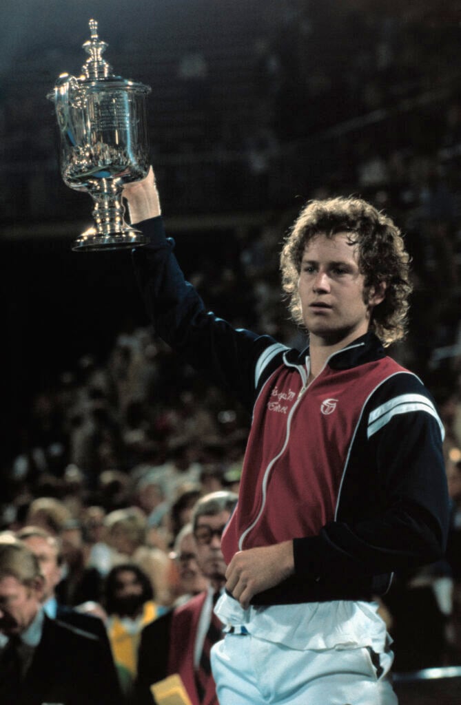 John McEnroe holds his trophy above his head after defeating Vitas Gerulaitis in the finals of the U.S. Open Men's Singles Championship here September 9th, by scores of 7-5, 6-3, 6-3.