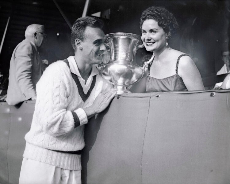 (Original Caption) Vic Seixas, 1953 Wimbledon champ, is shown with his wife and trophy after winning the U.S. Amateur Tennis Crown today. Going to ...